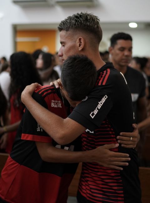 Flamengo youth soccer player Leoni Pereira, left, embraces a teammate during a memorial Mass for the victims of a fire at a Brazilian soccer academy, in Rio de Janeiro, Brazil, Friday, Feb. 8, 2019. A fire early Friday swept through the sleeping quarters of an academy for Brazil's popular professional soccer club Flamengo, killing 10 people and injuring three, most likely teenage players, authorities said. (AP Photo/Leo Correa)