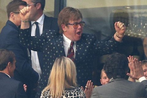 Former Watford owner Elton John celebrates in the stands after the English Premier League soccer match between Watford and Tottenham Hotspur at Vicarage Road, Watford, England, Sunday, Sept. 2, 2018. (Nigel French/PA via AP)