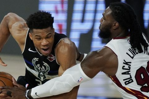 Miami Heat's Jae Crowder (99) knocks the ball loose from Milwaukee Bucks' Giannis Antetokounmpo (34), left, during the second half of an NBA conference semifinal playoff basketball game Wednesday, Sept. 2, 2020, in Lake Buena Vista, Fla. (AP Photo/Mark J. Terrill)