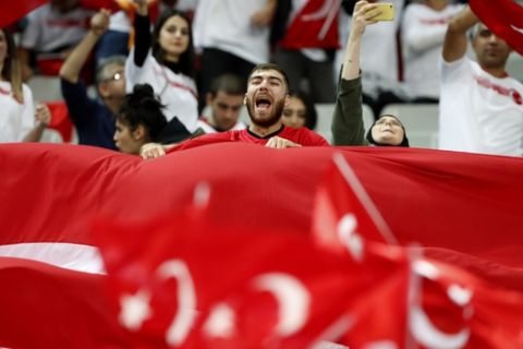 Turkish fans shout slogans and wave Turkish flags before the Euro 2020 group H qualifying soccer match between France and Turkey at Stade de France at Saint Denis, north of Paris, France, Monday, Oct. 14, 2019. (AP Photo/Thibault Camus)