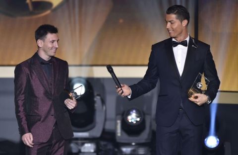 zzzzinte1Real Madrid and Portugal forward Cristiano Ronaldo hands a microhpone to Barcelona and Argentina forward Lionel Messi (L) as they stand on stage after being selected in the 2014 FIFA FIFPro World XI during the FIFA Ballon d'Or award ceremony at the Kongresshaus in Zurich on January 12, 2015. AFP PHOTO / FABRICE COFFRINI
zzzz