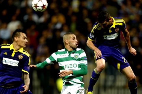 Sporting's Islam Slimani, center, fights for the ball with Maribor's Arghus, left and Maribor's Alen Ploj during the Champions League Group G soccer match between Maribor and Sporting, in Maribor, Slovenia, Wednesday, Sept. 17, 2014. (AP Photo/Darko Bandic) 