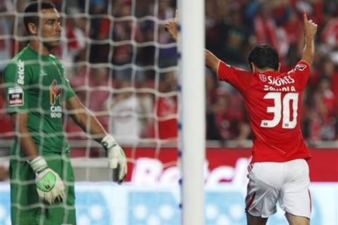 Benfica's Javier Saviola, right, from Argentina, celebrates after scoring the opening goal while Pacos Ferreira's goalkeeper Cassio Anjos, from Brazil,  reacts inside the goal during their Portuguese league soccer match Saturday, Oct. 1, 2011 at Benfica's Luz stadium in Lisbon. (AP Photo/ Francisco Seco)