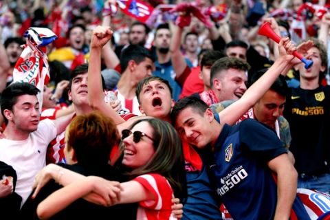 Atletico Madrid fans celebrates while watching the Europa League final between Atletico Madrid and Marseille on big screens after their team scored the first goal in the Wanda Metropolitano stadium in Madrid, Spain, Wednesday, May 16, 2018. (AP Photo/Paul White)