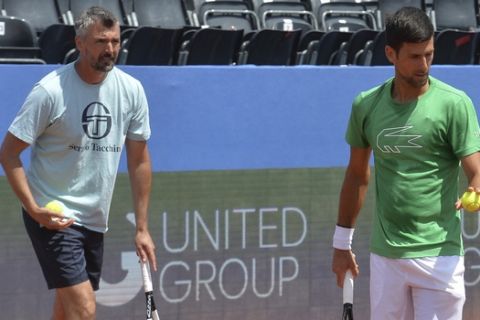In this photo taken June 18, 2020, former Wimbledon champion Goran Ivanisevic, left, who now coaches top-ranked Novak Djokovic, right, attends a training session during an exhibition tournament in Zadar, Croatia. The Croatian great, who won his only Grand Slam title at the All England Club in 2001, wrote on Instagram that he tested positive for coronavirus after two negative tests in the last 10 days. (AP Photo/Zvonko Kucelin)