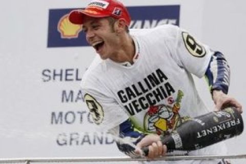 Italy's Valentino Rossi sprays champagne as he celebrates after winning the MotoGP World Championship with his third place finish at the Malaysian Grand Prix motorcycle racing at the Sepang International Circuit in Sepang, Malaysia, Sunday, Oct. 25, 2009. Australia's Casey Stoner won the race.   (AP Photo/Vincent Thian)