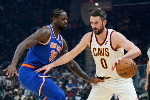 Cleveland Cavaliers' Kevin Love (0) drives against New York Knicks' Julius Randle (30) in the first half of an NBA basketball game, Monday, Jan. 24, 2022, in Cleveland. (AP Photo/Tony Dejak)