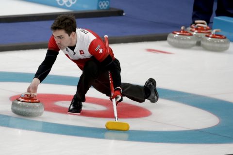 Switzerland's skip Peter de Cruz throws a stone during the men's bronze medal curling match against Canada at the 2018 Winter Olympics in Gangneung, South Korea, Friday, Feb. 23, 2018. (AP Photo/Natacha Pisarenko)