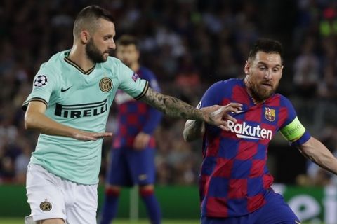 Inter Milan's Marcelo Brozovic, left, tries to stop Barcelona's Lionel Messi during the group F Champions League soccer match between F.C. Barcelona and Inter Milan at the Camp Nou stadium in Barcelona, Spain, Wednesday, Oct. 2, 2019. (AP Photo/Emilio Morenatti)