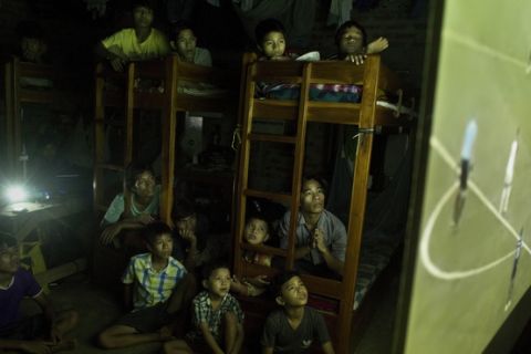 Indian children at a school hostel watch  a projection of the World Cup soccer final match between France and Croatia on the outskirts of Gauhati, India, Sunday, July 15, 2018. (AP Photo/Anupam Nath)
