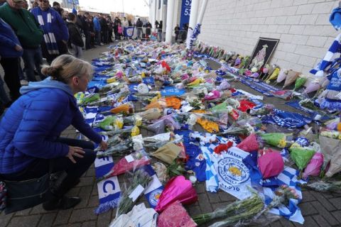 Flowers are placed outside Leicester City Football Club after a helicopter crashed in flames the previous day, in Leicester, England, Sunday, Oct. 28, 2018. A helicopter belonging to Leicester City's owner  Thai billionaire Vichai Srivaddhanaprabha  crashed in flames in a car park next to the soccer club's stadium shortly after it took off from the field following a Premier League game on Saturday night. (Aaron Chown/PA via AP)