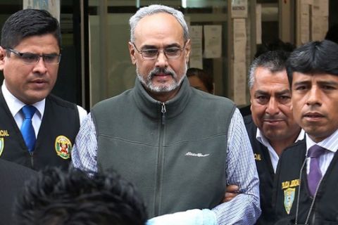 FILE - In this Dec. 7, 2015 file photo, provided by state-run Andina Agency, police escort Manuel Burga, the former head of Peru's soccer federation, outside court in Lima, Peru. Burga was extradited to the United States on Friday, Dec. 2, 2016, to face charges for his alleged involvement in a multibillion-dollar FIFA bribery scandal involving marketing and broadcasting rights. (Andina Agency/Norman Cordova via AP, File)