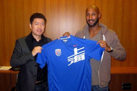 ---- EDITORS NOTE ---- RESTRICTED TO EDITORIAL USE MANDATORY CREDIT "AFP PHOTO/Shanghai Shenhua Club/NO MARKETING NO ADVERTISING CAMPAIGNS - DISTRIBUTED AS A SERVICE TO CLIENTS
This handout picture released by Shanghai Shenhua Club on December 12, 2011 shows Chelsea striker Nicolas Anelka (R) holding a Jersey of the Shenhua club as he poses with Shenhua club's investor Zhujun in Paris. Shanghai Shenhua said on December 12 that Chelsea striker Nicolas Anelka will start a two-year contract with the club in January, in a major coup for Chinese football which has been plagued by scandals.    AFP PHOTO / Shanghai Shenhua Club (Photo credit should read Shanghai Shenhua Club/AFP/Getty Images)