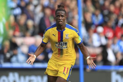 Crystal Palace's Wilfried Zaha celebrates scoring his side's first goal of the game during the English Premier League soccer match between Huddersfield and Crystal Palace, at the Kirklees Stadium, in Huddersfield, England, Saturday Sept. 15, 2018. (Mike Egerton/PA via AP)