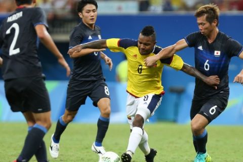 Colombia's Dorlan Pabon, 2nd right, fights for the ball with Japan's Sei Maroya, left, Japan's Ryota Oshima, 2nd left, and Japan's Tsukasa Shiotani during a group B match of the men's Olympic football tournament between Japan and Colombia at the Amazonia Arena, in Manaus, Brazil, Sunday, Aug. 7, 2016. (AP Photo/Michael Dantas)
