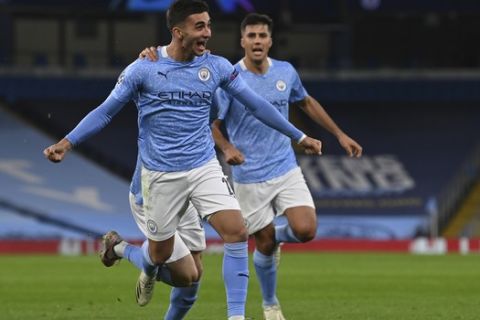 Manchester City's Ferran Torres, left, celebrates scoring his sides third goal during the Champions League group C soccer match between Manchester City and FC Porto at the Etihad stadium in Manchester, England, Wednesday, Oct. 21, 2020. (Paul Ellis/Pool via AP)