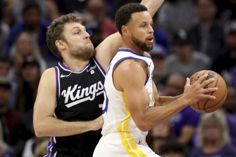 Golden State Warriors guard Stephen Curry drives to the basket against Sacramento Kings forward Sasha Vezenkov, left, during the first half of an NBA basketball game in Sacramento, Calif, Friday, Oct. 27, 2023. (AP Photo/Jed Jacobsohn)