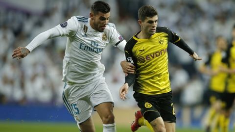 Real Madrid's Theo Hernandez and Dortmund's Christian Pulisic, from left, challenge for the ball during the Champions League Group H soccer match between Real Madrid and Borussia Dortmund at the Santiago Bernabeu stadium in Madrid, Spain, Wednesday, Dec. 6, 2017. (AP Photo/Paul White)