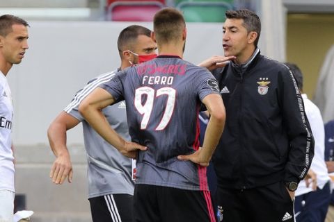 Benfica's head coach Bruno Lage, right, talks to defender Ferro, center, as goalkeeper Odysseas Vlachodimos, left, looks on at the end of the Portuguese League soccer match between Maritimo and Benfica at the Maritimo stadium in Funchal, Portugal, Monday, June 29, 2020. The Portuguese League soccer matches are being played without spectators because of the coronavirus pandemic. Maritimo won 2-0. (Gregorio Cunha/Pool via AP)