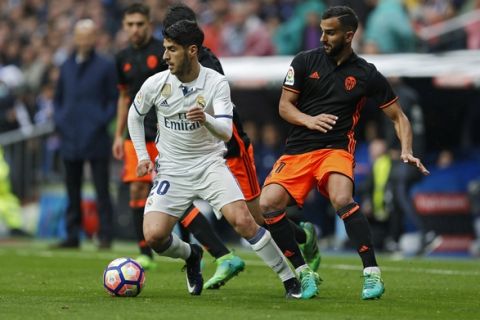 Real Madrid's Marco Asensio, left, battles for the ball with Valencia's Martin Montoya, right, during the Spanish La Liga soccer match between Real Madrid and Valencia at the Santiago Bernabeu stadium in Madrid, Saturday, April 29, 2017. Real Madrid won 2-1. (AP Photo/Francisco Seco)