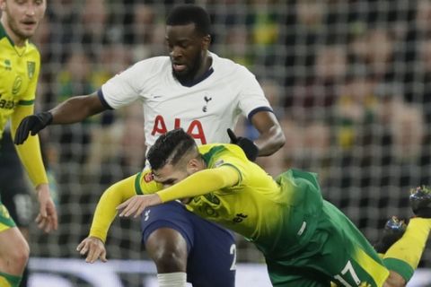 Tottenham's Tanguy Ndombele, left, challenges for the ball with Norwich City's Emi Buendia, during the English FA Cup fifth round soccer match between Tottenham Hotspur and Norwich City at Tottenham Hotspur stadium in London Wednesday, March 4, 2020. (AP Photo/Kirsty Wigglesworth)