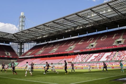 Players of Cologne and Frankfurt challenge for there ball in front of empty stands during the German Bundesliga soccer match between 1. FC Cologne and Eintracht Frankfurt in Cologne, Germany, Saturday, June 20, 2020. (Rolf Vennenbernd/Pool via AP)