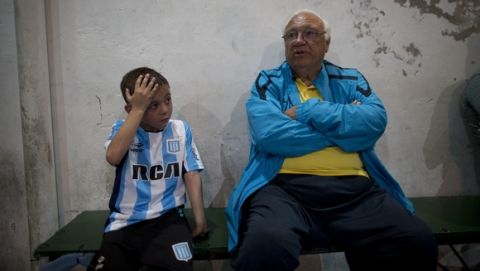 In this Nov. 11, 2016 photo, head soccer talent scout Ramon Maddoni, of Club Social Parque and Boca Juniors children's division, sits on the bench with young player Benjamin Palandella at the youth soccer academy Club Social Parque in a working class neighborhood of Buenos Aires, Argentina. "At Club Parque, we work a lot on the fundamentals, the technique. We recognize talent from a young age and our eye has been sharpening with time," said Maddoni. (AP Photo/Natacha Pisarenko)