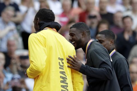 United States' gold medal winner Justin Gatlin, center, United States' silver medal winner Christian Coleman, right, and Jamaica's bronze medal winner Usain Bolt on the podium during the ceremony for the men's 100-meter final at the World Athletics Championships in London Sunday, Aug. 6, 2017. (AP Photo/Matthias Schrader)
