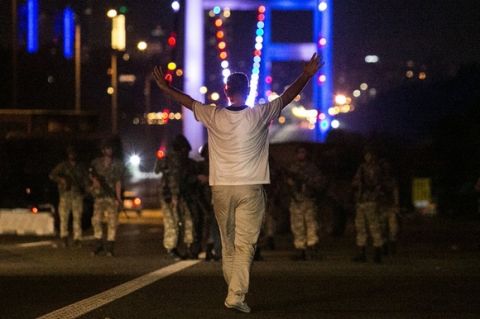 A man approaches Turkish military with his hands up at the entrance to the Bosphorus bridge in Istanbul on July 16, 2016. 
Turkish security forces on July 15 partially shut down the two bridges across the Bosphorus Strait in Istanbul. Turkish military forces on July 16 opened fire on crowds gathered in Istanbul following a coup attempt, causing casualties, an AFP photographer said.  / AFP / Bulent KILIC AND GURCAN OZTURK        (Photo credit should read BULENT KILIC,GURCAN OZTURK/AFP/Getty Images)