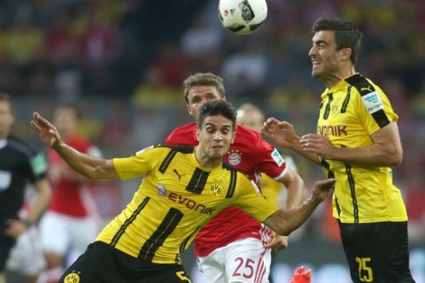Dortmund's Marc Bartra, left,  team mate  Sokratis Papastathopoulos, right, and Munich's Thomas Mueller (challenge for the ball during the German Super Cup match between Borussia Dortmund and Bayern Munich in Dortmund, Germany, Sunday, Aug. 14, 2016. (Ina Fassbender/dpa via AP)