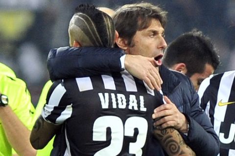 Juventus coach Antonio Conte celebrates with Arturo Vidal and Martin Caceres after a Serie A soccer match between Juventus and Inter Milan at the Juventus stadium, in Turin, Italy, Sunday, Feb. 2, 2014. (AP Photo/Massimo Pinca)