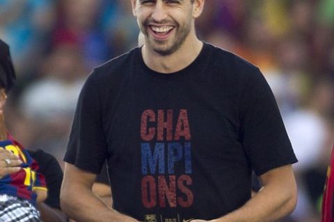 Barcelona's defender Gerard Pique smiles during a gathering with supporters at the Camp Nou stadium in Barcelona on May 29, 2011 a day after the team won the UEFA Champions League final football match against Manchester United.  AFP PHOTO/ JAIME REINA (Photo credit should read JAIME REINA/AFP/Getty Images)