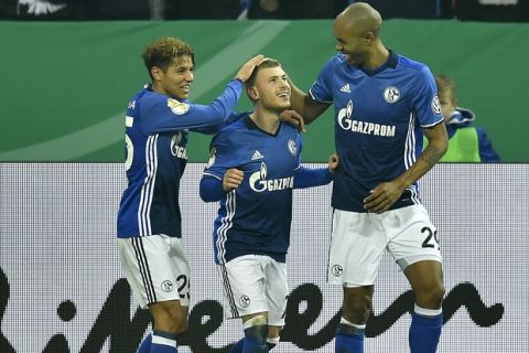 Schalke's Max Meyer, center, is celebrated by Amine Harit, left, and Naldo, right, after scoring the opening goal during the German soccer cup match between FC Schalke 04 and 1. FC Cologne in Gelsenkirchen, Germany, Tuesday, Dec. 19, 2017. (AP Photo/Martin Meissner)
