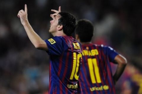 FC Barcelona's Lionel Messi from Argentina, left, reacts after scoring against Villarreal goalkeeper Diego Lopez during a Spanish La Liga soccer match at the Camp Nou stadium in Barcelona, Spain, Monday, Aug. 29, 2011. (AP Photo/Manu Fernandez)