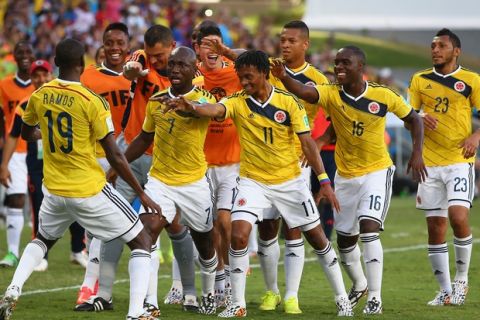CUIABA, BRAZIL - JUNE 24:  Juan Guillermo Cuadrado of Colombia (center) celebrates with teammates scoring his team's first goal after a penalty kick during the 2014 FIFA World Cup Brazil Group C match between Japan and Colombia at Arena Pantanal on June 24, 2014 in Cuiaba, Brazil.  (Photo by Mark Kolbe/Getty Images)