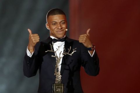 Paris St Germain's Kylian Mbappe celebrates with the Kopa Trophy during the Golden Ball, "Ballon d'Or" award ceremony at the Grand Palais in Paris, France, Monday, Dec.3, 2018. Awarded every year by France Football magazine since Stanley Matthews won it in 1956, the Ballon d'Or, Golden Ball for the best player of the year will be given to both a woman and a man. (AP Photo/Christophe Ena)