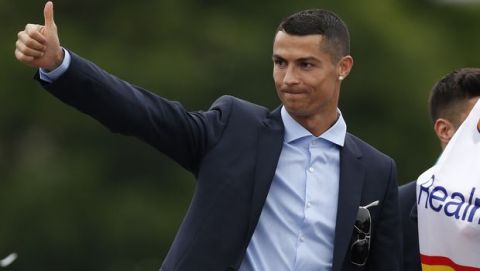 Real Madrid's Cristiano Ronaldo gestures to supporters as he celebrates with teammates after winning the Champions League final soccer match, at the Cibeles square in Madrid, Spain, Sunday, May 27, 2018. (AP Photo/Francisco Seco)
