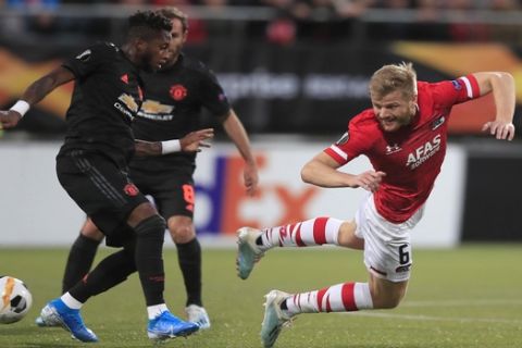 Manchester United's Fred, left, and Alkmaar's Fredrik Midtsjo vie for the ball during the group L Europa League soccer match between AZ Alkmaar and Manchester United at the ADO Den Haag stadium in The Hague, Netherlands, Thursday, Oct. 3, 2019. (AP Photo/Peter Dejong)
