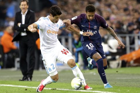 Marseille's Hiroki Sakai, left, challenges for the ball with PSG's Neymar during the League One soccer match between Marseille and Paris Saint-Germain, at the Velodrome stadium, in Marseille, southern France, Sunday, Oct. 22, 2017. (AP Photo/Claude Paris)