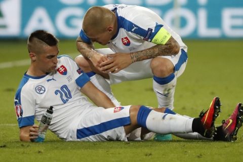 Slovakia's Martin Skrtel, right, talks with teammate Robert Mak during the Euro 2016 Group B soccer match between Slovakia and England at the Geoffroy Guichard stadium in Saint-Etienne, France, Monday, June 20, 2016. (AP Photo/Francois Mori)