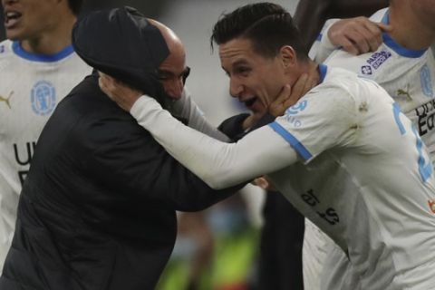 Marseille's Florian Thauvin, right, celebrates with Marseille's coach Jorge Sampaoli after scoring his side's second goal during the French League One soccer match between Marseille and Brest at the Stade Veledrome stadium in Marseille, France, Saturday, March 13, 2021. (AP Photo/Daniel Cole)