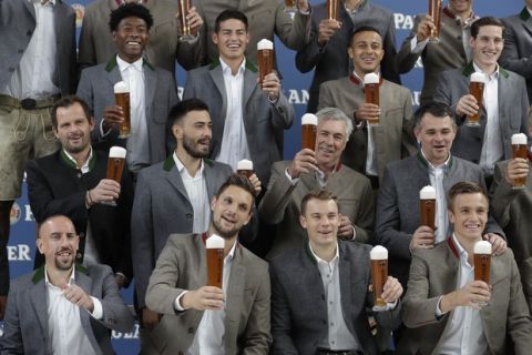 Bayern coach Carlo Ancelotti, center, and his team pose with beer in traditional Bavarian clothes during a photo shooting of a brewing company in Munich, Germany, Wednesday, Sept. 13, 2017. (AP Photo/Matthias Schrader)