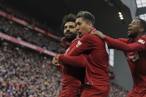 Liverpool's Mohamed Salah, left, Roberto Firmino, center, and Georginio Wijnaldum celebrate after Tottenham's Toby Alderweireld scores an own goal past his goalkeeper during the English Premier League soccer match between Liverpool and Tottenham Hotspur at Anfield stadium in Liverpool, England, Sunday, March 31, 2019. (AP Photo/Rui Vieira)