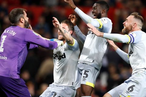 Derby County goalkeeper Scott Carson, left, celebrates winning the penalty shootout with team mates during the match against Manchester United during the English League Cup, third round soccer match at Old Trafford in Manchester, England, Tuesday Sept. 25, 2018. (Martin Rickett/PA via AP)