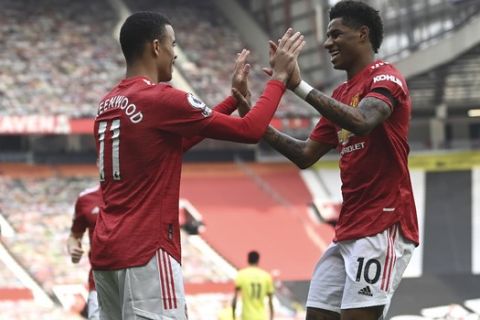 Manchester United's Mason Greenwood, left, celebrates with Manchester United's Marcus Rashford after scoring his side's opening goal during the English Premier League soccer match between Manchester United and Burnley at the Old Trafford stadium in Manchester, England, Sunday, April 18, 2021. (Gareth Copley/Pool via AP)