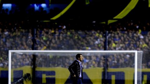 Rodolfo Arruabarrena, coach of Boca Juniors, stands on the field before the start of the second half of a Copa Libertadores soccer match against River Plate in Buenos Aires, Argentina, Thursday, May 14, 2015. The match between the bitter the Argentine rivals was suspended after River Plate players were sprayed with a substance that seemed to affect their vision and irritated their eyes. (AP Photo/Natacha Pisarenko)