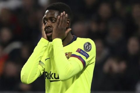 Barcelona forward Ousmane Dembele holds his face during the Champions League round of 16 first leg soccer match between Lyon and FC Barcelona in Decines, near Lyon, central France, Tuesday, Feb. 19, 2019. (AP Photo/Laurent Cipriani)