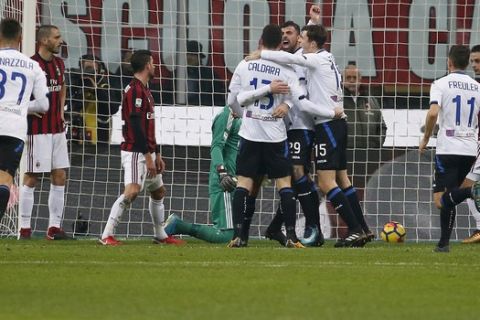 Atalanta's Bryan Cristante, covered by his teammates, celebrates after scoring his side's opening goal during the Serie A soccer match between AC Milan and Atalanta at the San Siro stadium in Milan, Italy, Saturday, Dec. 23, 2017. (AP Photo/Antonio Calanni)