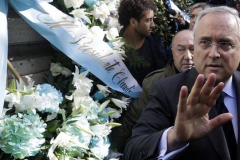 Lazio soccer team president Claudio Lotito gives a statement to the press after laying a wreath outside Rome's Synagogue, Tuesday, Oct. 24, 2017. Lazio fans have a long history of racism and anti-Semitism and the Roman club's supporters established another low over the weekend when they littered the Stadio Olimpico with superimposed images of Anne Frank _ the young diarist who died in the Holocaust _ wearing a jersey of city rival Roma. In the background left is Lazio player Felipe Anderson. (AP Photo/Gregorio Borgia)