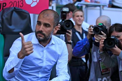 Bayern head coach Josep Guardiola, left, is surrounded by photographers prior the Telekom Cup semifinal soccer match between HSV Hamburg and Bayern Munich in Moenchengladbach, Germany, Saturday, July 20, 2013. (AP Photo/Frank Augstein) 